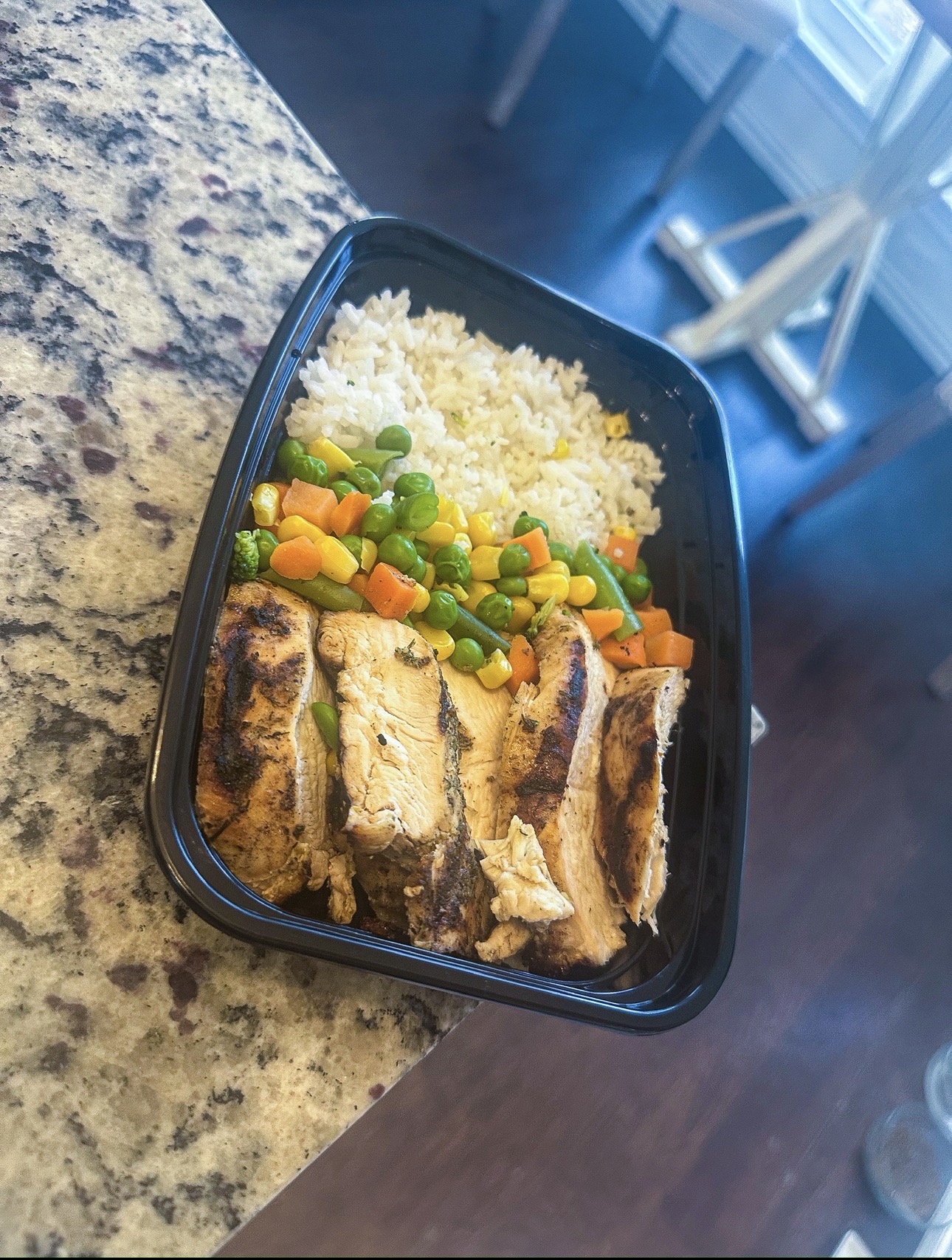 Grilled chicken with rice and mixed vegetables in a high protein O Life meal prep container