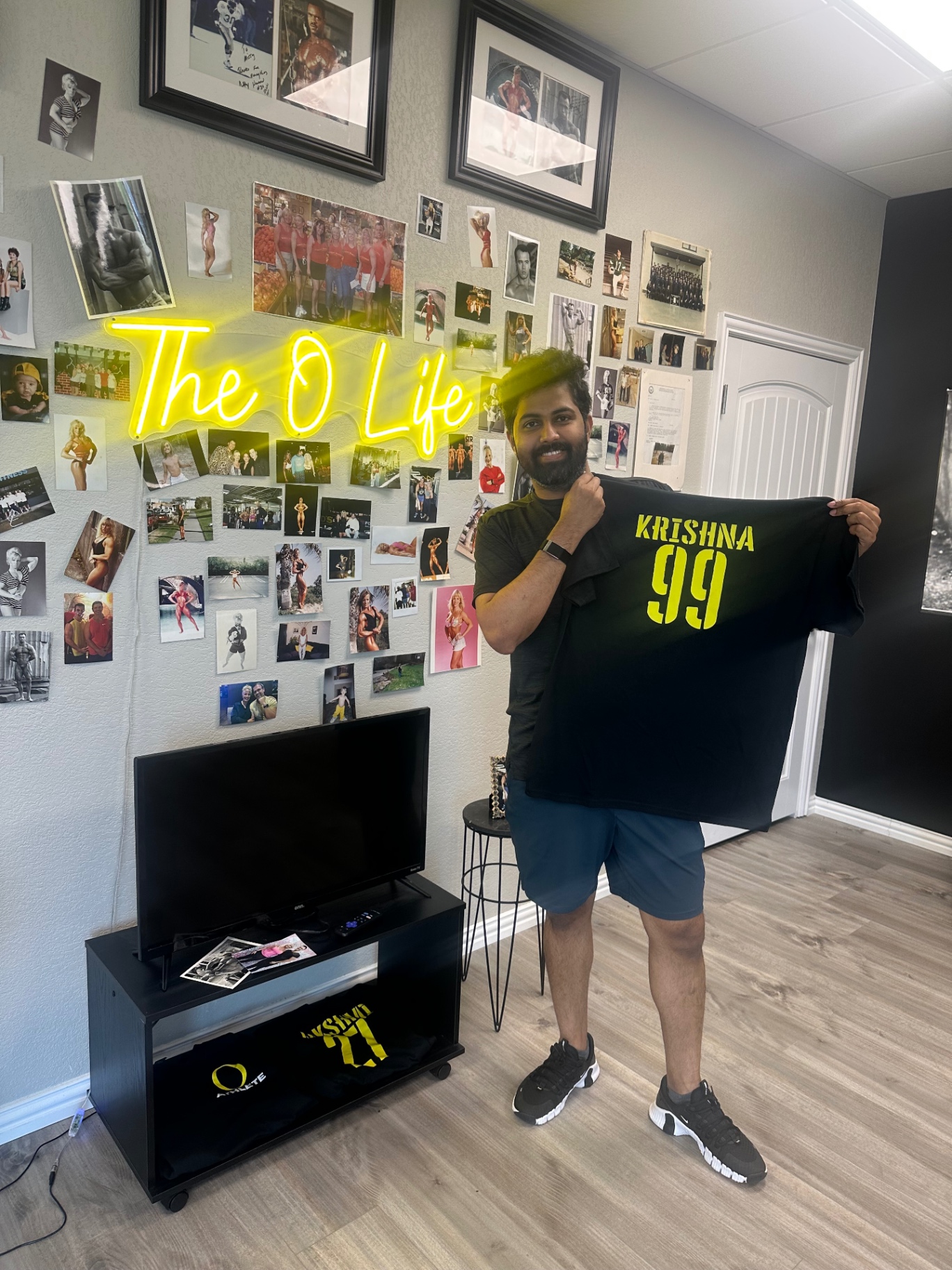 Krishna holding his O Life athlete jersey, number 99