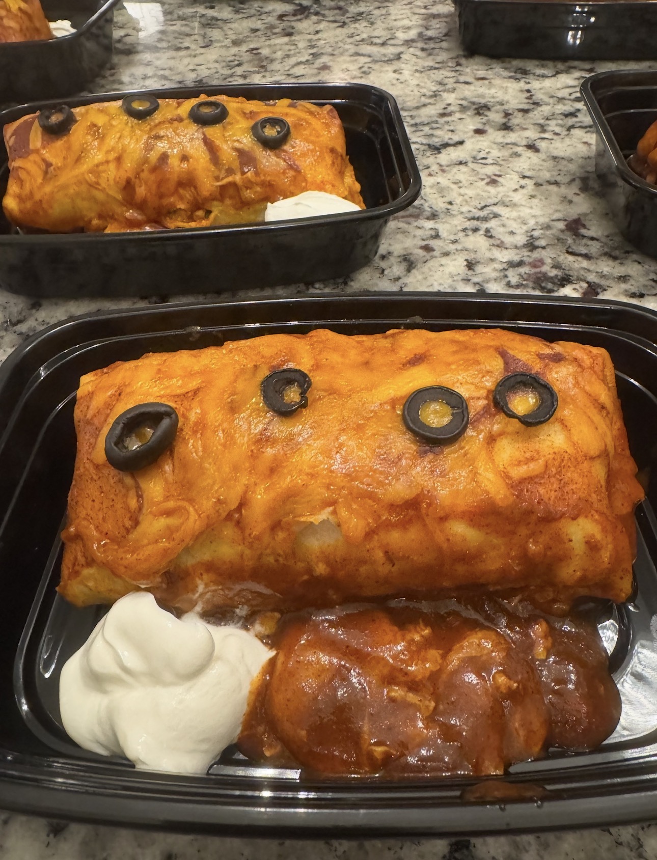 Smothered chicken burrito with sour cream in a healthy meal prep container prepared in Little Elm, Texas