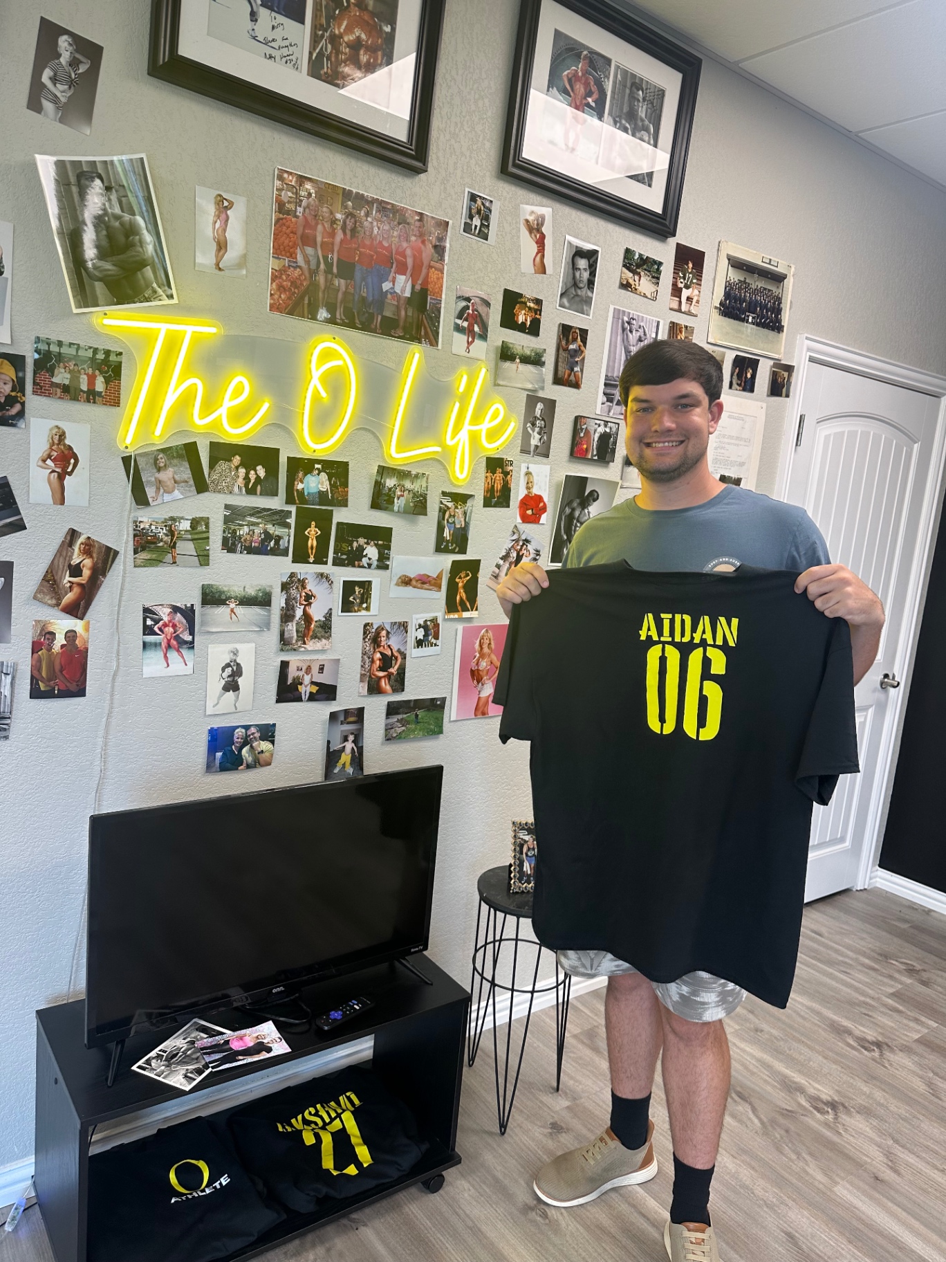Aidan holding his O Life athlete jersey, number 06