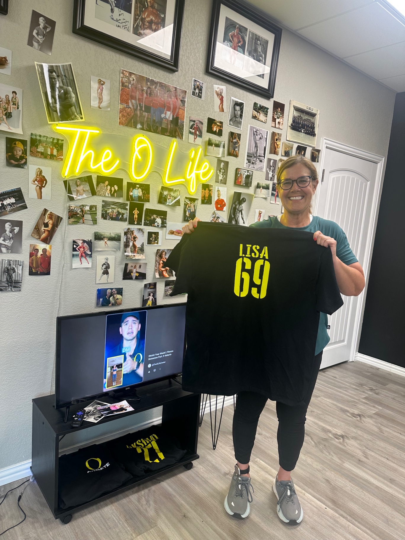 Lisa holding her O Life athlete jersey, number 69